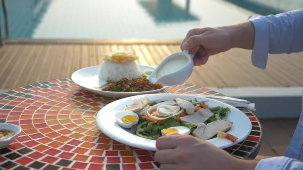 Räksoppa är en thailändsk maträtt med en syrlig och kryddig smak. mannen äter Tom Yam vid ett bord vid poolen. närbild. begreppet turism turism — Stockfoto