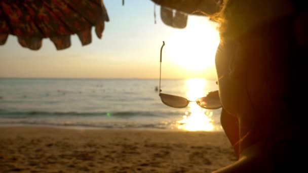 Schöner sonniger Sonnenuntergang am Meer. Blick durch eine Sonnenbrille. Frau mit Sonnenbrille blickt auf den Sonnenuntergang am Meer — Stockvideo