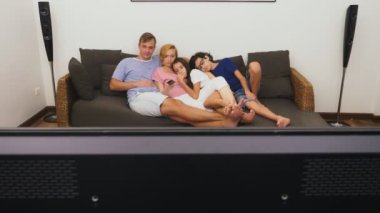 Büyüleyici aile, Anne, Baba, kızı ve oğlu oturma odasında birlikte Tv izliyor musun