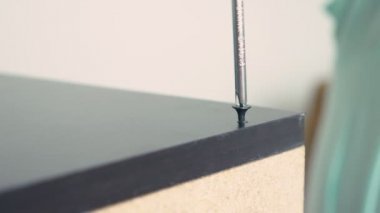 Genç bir adam bağımsız olarak mobilya evinin oturma odasında toplar. Bir adam bilgisayar masası toplar.