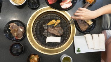 Korece Barbekü ızgara. aşçı insanlar ve bir restoranda Kore bir ızgarada pişmiş yemekler yiyin. yakın çekim.