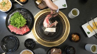 Korece Barbekü ızgara. aşçı insanlar ve bir restoranda Kore bir ızgarada pişmiş yemekler yiyin. yakın çekim.