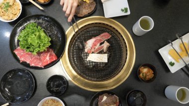 Korece Barbekü ızgara. aşçı insanlar ve bir restoranda Kore bir ızgarada pişmiş yemekler yiyin. yakın çekim.