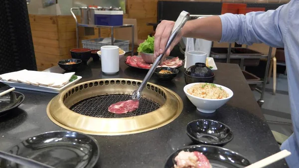 Koreansk grill grill. människor cook och äta rätter som tillagas på en koreansk grill i en restaurang. närbild. — Stockfoto