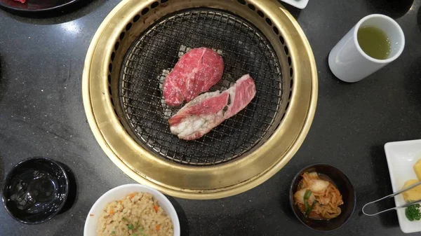 Korece Barbekü ızgara. aşçı insanlar ve bir restoranda Kore bir ızgarada pişmiş yemekler yiyin. yakın çekim.