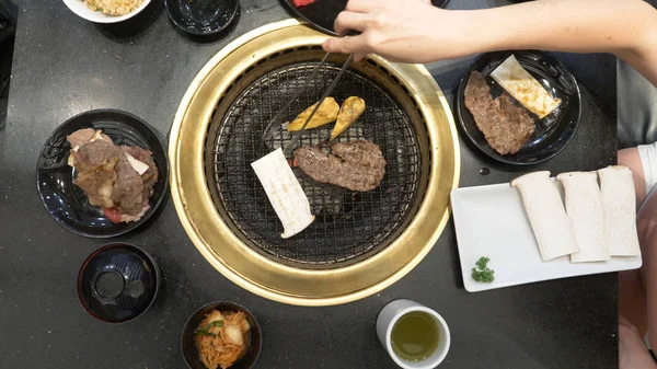 Korece Barbekü ızgara. aşçı insanlar ve bir restoranda Kore bir ızgarada pişmiş yemekler yiyin. yakın çekim.