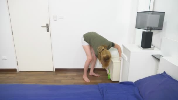 Mujer joven limpiando el dormitorio con productos y equipos de limpieza, concepto de trabajo doméstico — Vídeos de Stock