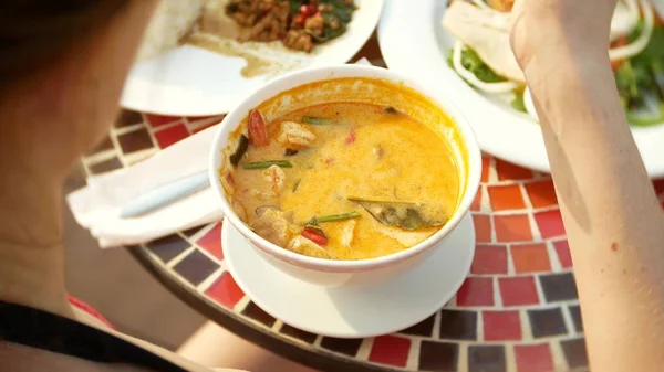Krewetki pikantne zupy jest tajskie danie z kwaśny i ostry smak. Busty dziewczyna w bikini zjada Tom Yam przy stole przy basenie. szczelnie-do góry. pojęcie turystyki podróży — Zdjęcie stockowe