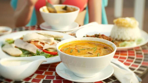 Sopa picante de camarão é um prato tailandês com sabor azedo e picante. menina peituda em um biquíni come Tom Yam em uma mesa à beira da piscina. close-up. conceito de turismo de viagens — Fotografia de Stock