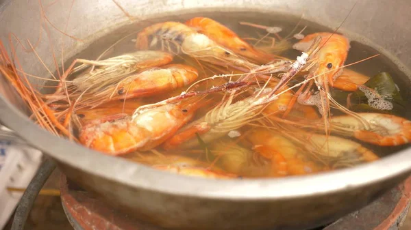 close-up, someone cooks shrimps in a saucepan