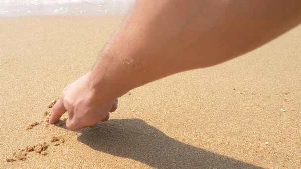 The sea wave erases the inscriptions written on the sand. top view. — Stock Photo, Image