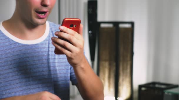 Un hombre usando su teléfono inteligente. mirando a través de contenido erótico. él coquetea hablando en vídeo — Vídeos de Stock