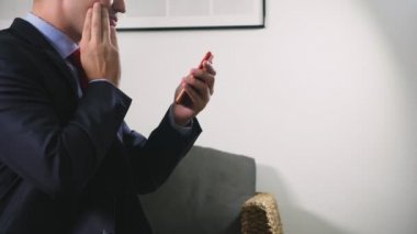 Güzel eşcinsel akşamları oturma odasında otururken hücresel bir akıllı telefon kullanın. Mutlu gülümseyen genç adam evde internet sohbet.