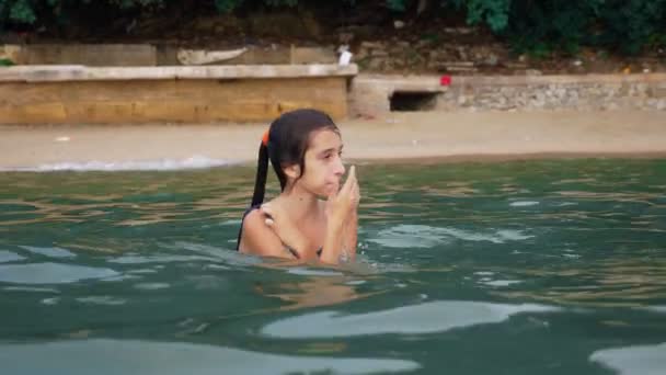 Gelukkig tiener meisje in de zee spelen. meisje stoeit gelukkig op het strand. Zomervakantie en actieve levensstijl concept — Stockvideo