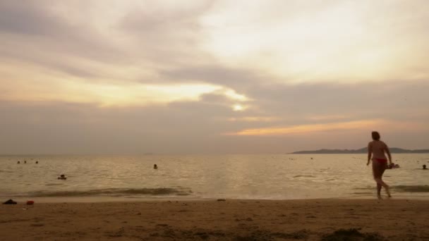 Idő telik el. gyönyörű naplemente a tengerparton. valaki úszik a tengerben, este — Stock videók