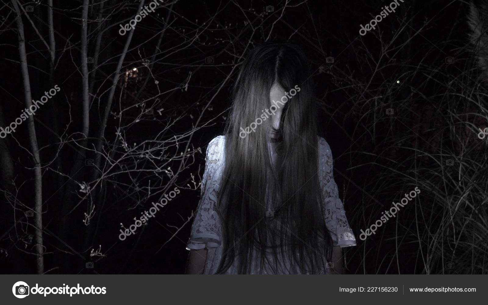 A little ghost girl with long black hair, in white, wandering through the  woods with a knife and a soft toy. Stock Photo by ©kopitin 227156230