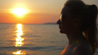 denizde güzel güneşli gün batımı. güneş gözlüğü ile görüntüleyin. kadın güneş gözlüğü günbatımında denizin üzerinde görünüyor.