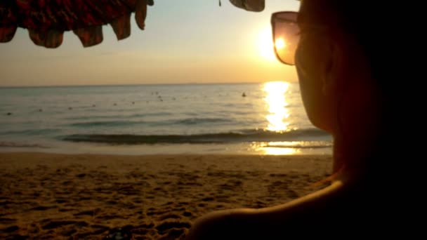 Denizde güzel güneşli gün batımı. güneş gözlüğü ile görüntüleyin. kadın güneş gözlüğü günbatımında denizin üzerinde görünüyor. — Stok video