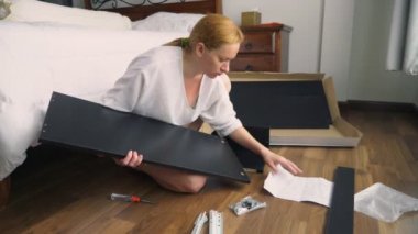 Evde mobilya montaj, bir ev kadını araya el aletleri kullanarak bir bilgisayar masası.