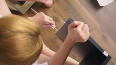 Evde mobilya montaj, bir ev kadını araya el aletleri kullanarak bir bilgisayar masası.