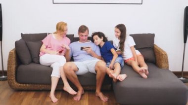 Büyüleyici aile, Anne, Baba, kızı ve oğlu oturma odasında birlikte Tv izliyor musun