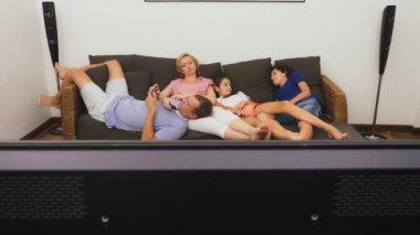 Büyüleyici aile, Anne, Baba, kızı ve oğlu oturma odasında birlikte Tv izliyor musun