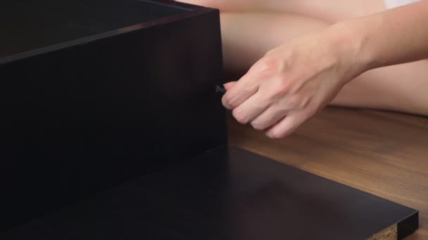 Assembling furniture at home, a housewife assembles a computer desk using hand tools. — Stock Video