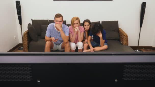 Charmante familie, moeder, vader, dochter en zoon zijn Tv-kijken in de woonkamer samen — Stockvideo