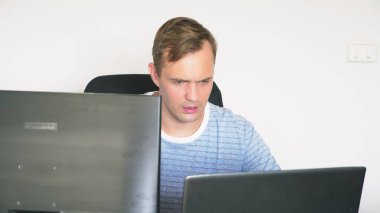 Çalışma evde bilgisayar ve dizüstü bilgisayar vasıl ev, Masa başında oturan bir adam.