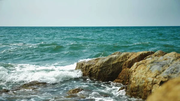 Seelandschaft. Steine an der Meeresküste, Wellen und Meerschaum. — Stockfoto