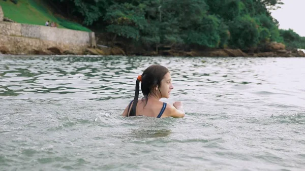 Glückliches Teenie-Mädchen, das im Meer spielt. Mädchen tobt fröhlich am Strand. Sommerurlaub und aktives Lifestylekonzept — Stockfoto