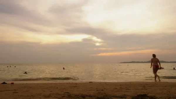 Idő telik el. gyönyörű naplemente a tengerparton. valaki úszik a tengerben, este — Stock Fotó