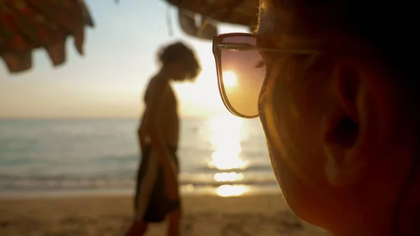 Schöner sonniger Sonnenuntergang am Meer. Blick durch eine Sonnenbrille. Frau mit Sonnenbrille blickt auf den Sonnenuntergang am Meer — Stockfoto