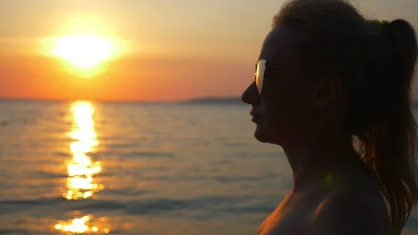 Schöner sonniger Sonnenuntergang am Meer. Blick durch eine Sonnenbrille. Frau mit Sonnenbrille blickt auf den Sonnenuntergang am Meer — Stockfoto