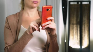 Kadın onun akıllı telefonda oyun oynamak.