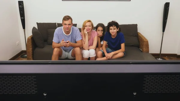 迷人的家庭、妈妈、爸爸、女儿和儿子一起在客厅里看着电视 — 图库照片