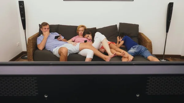 Familia encantadora, mamá, papá, hija e hijo están viendo la televisión en la sala de estar juntos, durmiendo frente a la televisión — Foto de Stock