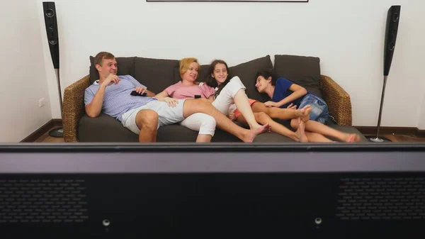 Familia encantadora, mamá, papá, hija e hijo están viendo la televisión en la sala de estar juntos, durmiendo frente a la televisión —  Fotos de Stock