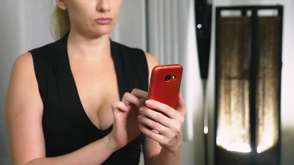 Портрет молодой серьезной женщины, вечером и с использованием смартфона с сенсорным экраном . — стоковое фото