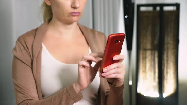 Retrato de jovem mulher séria, à noite e usando o smartphone com tela sensível ao toque . — Fotografia de Stock