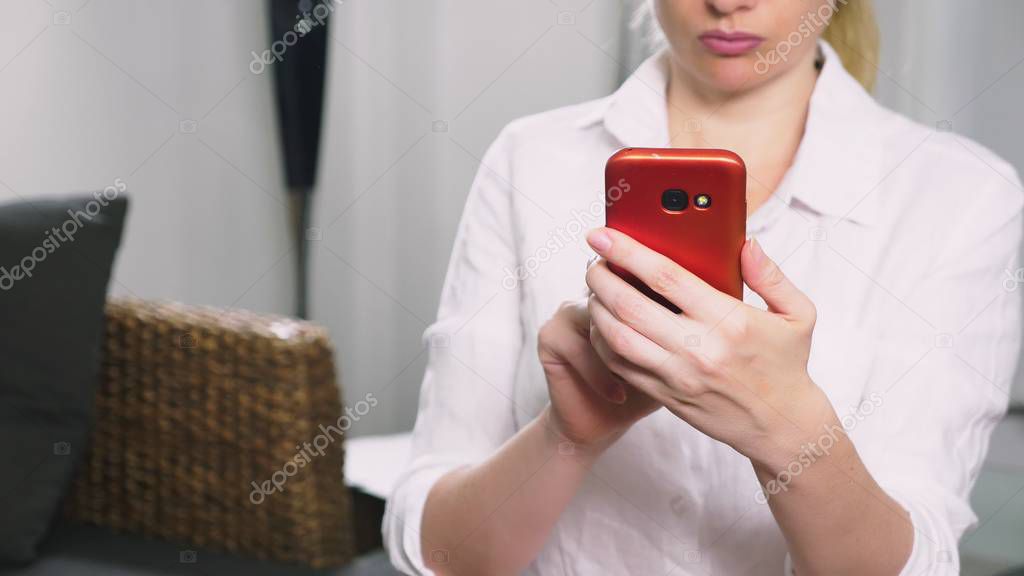 Portrait of young serious woman , in the evening and using the smartphone with touchscreen.