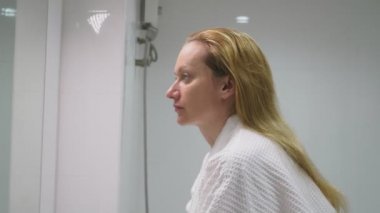 Yüz bakım kavramı. Kadın banyoda derinin dikkat çekmek için kozmetik losyon uygulamak. Sabah hijyen