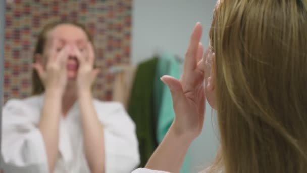 Koncept péče o tvář. Žena nanášení kosmetických, pečovat o kůži v koupelně. Ranní hygiena — Stock video