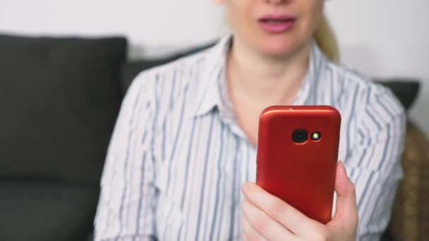 Женщина флиртует, разговаривая на видео со своего смартфона. Женщина посылает поцелуй онлайн во время видеозвонка с помощью смартфона . — стоковое видео