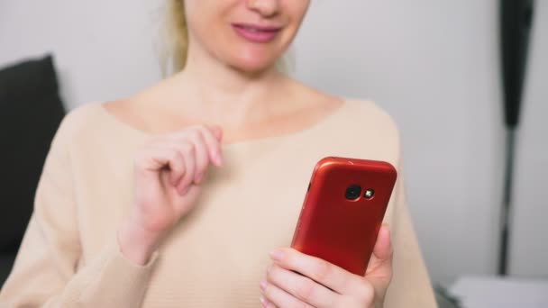 Γυναίκα φλερτάρει μιλώντας σχετικά με την ανακοίνωση του βίντεο από το smartphone της. Μια γυναίκα στέλνει ένα φιλί online κατά τη διάρκεια μιας κλήσης βίντεο χρησιμοποιώντας ένα smartphone. — Αρχείο Βίντεο