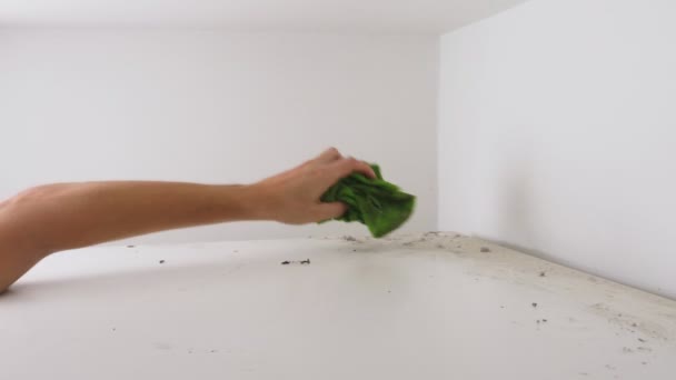 Koncepce úklidu. muž otírá prach z vysoké skříně ve svém domě — Stock video