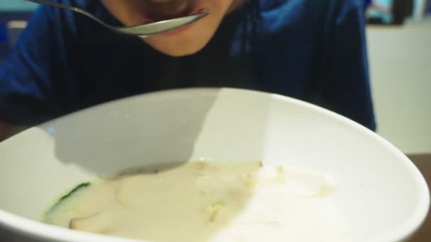 Sopa de camarão é um prato tailandês com um sabor azedo e picante. O homem come Tom Yam a uma mesa num restaurante. close-up. conceito de turismo turismo — Vídeo de Stock