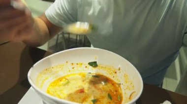 Karides çorbası ekşi ve baharatlı tadı ile Tay bir yemektir. adam tom yam bir restoranda bir masada yemek yer. yakın çekim. Turizm Turizm kavramı