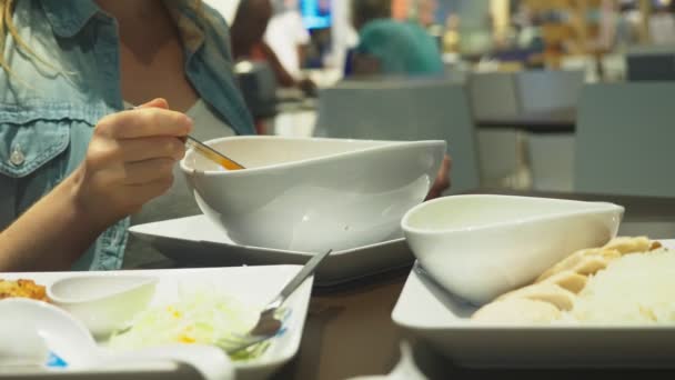 La zuppa di gamberetti è un piatto tailandese dal sapore aspro e piccante. L'uomo mangia Tom Yam a un tavolo in un ristorante. primo piano. concetto di turismo turistico — Video Stock