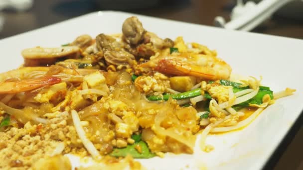 Primer plano. alguien come un plato de cocina asiática en un restaurante . — Vídeo de stock